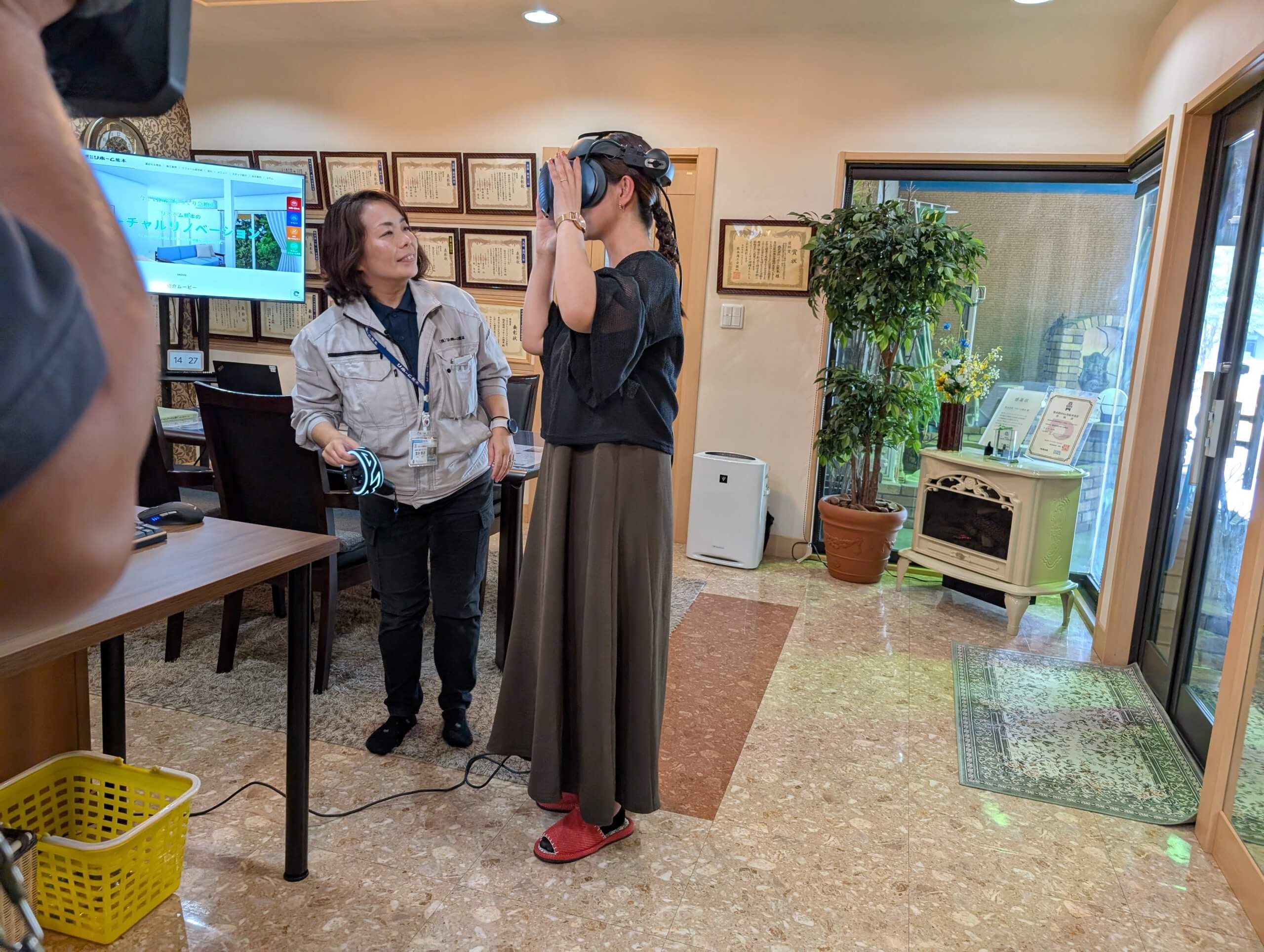 ゴーグルをのぞき込み、仮想現実の画像に驚くインタビュアーの画像